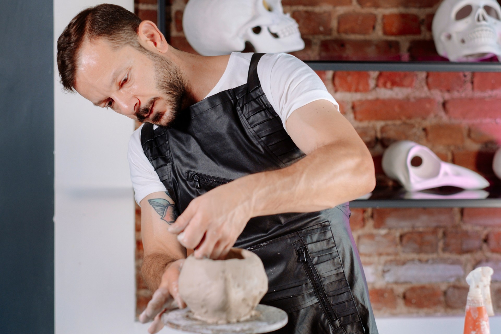 Man crafting clay sculpture in an art studio