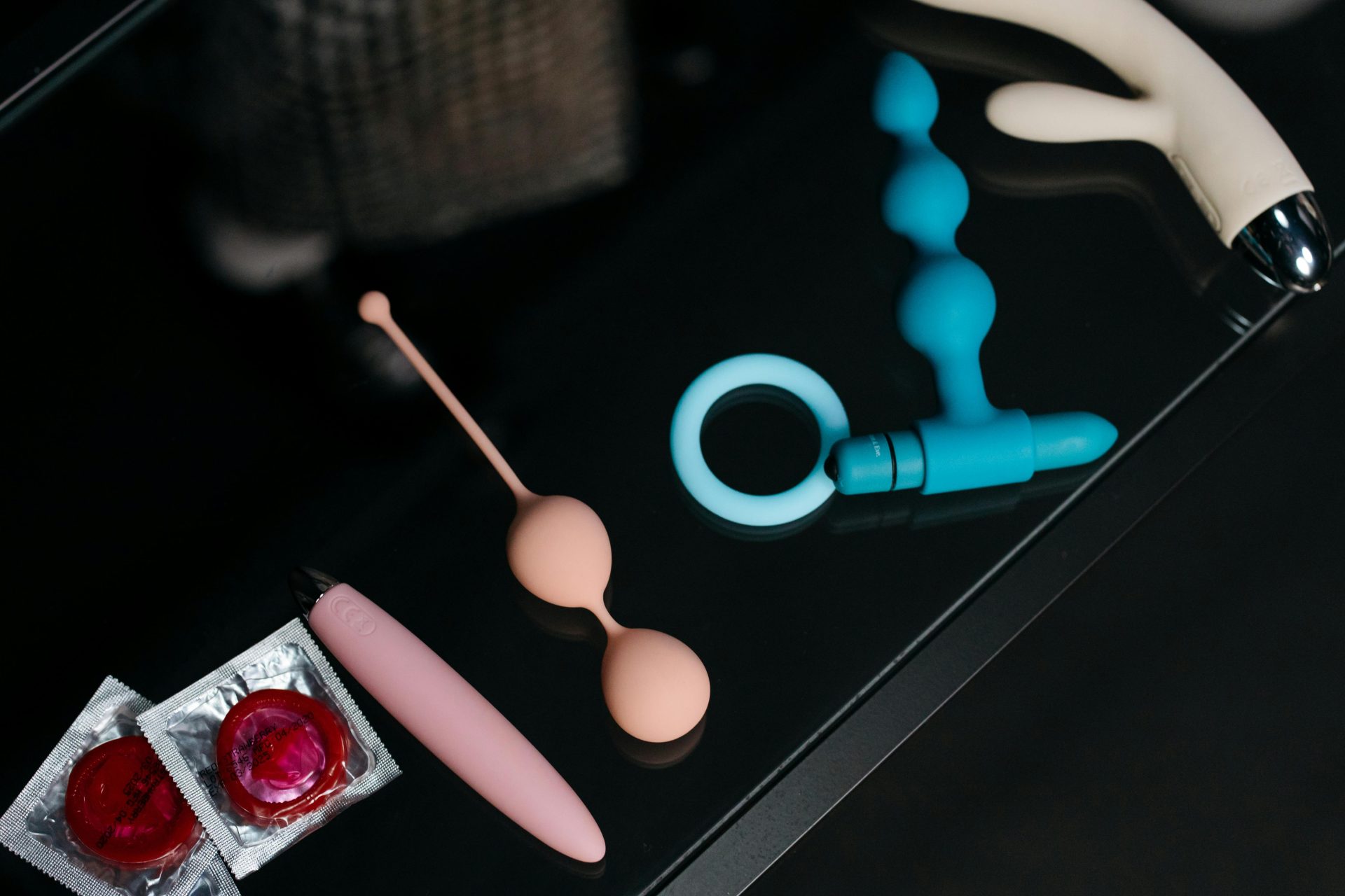 Various colorful sex toys on a glass table